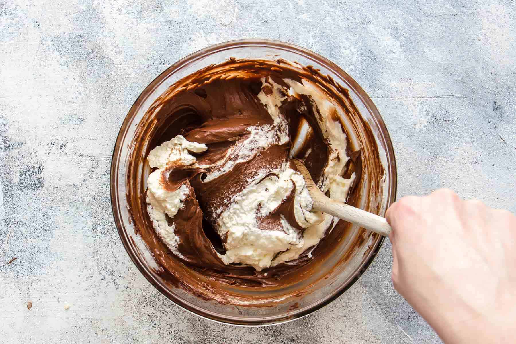 folding whipped cream into chocolate cream with spoon pointing to 3