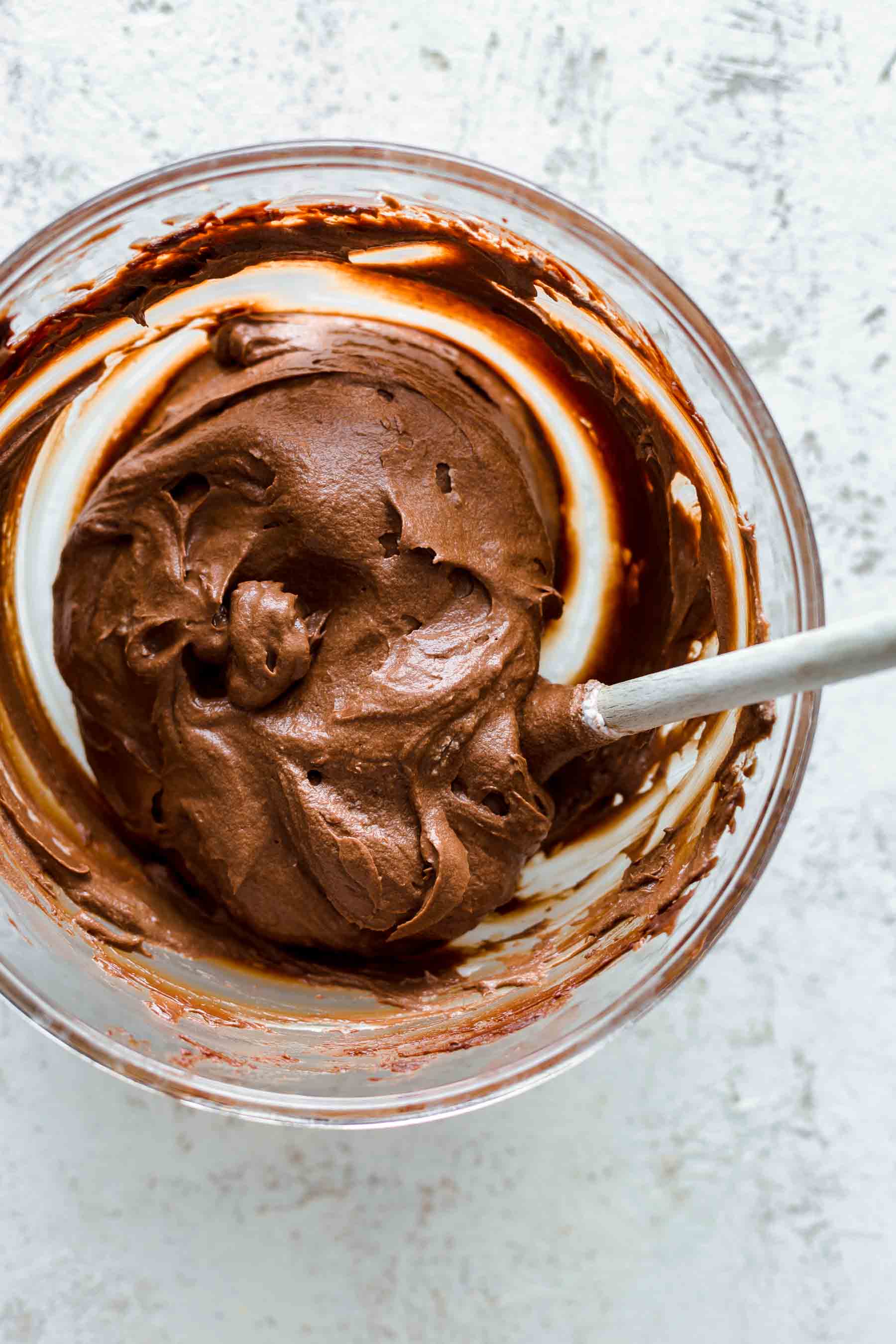 whipped chocolate mousse in mixing bowl with wooden spoon