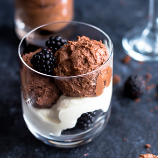 Chocolate Mousse in glass with whipping cream and blackberries