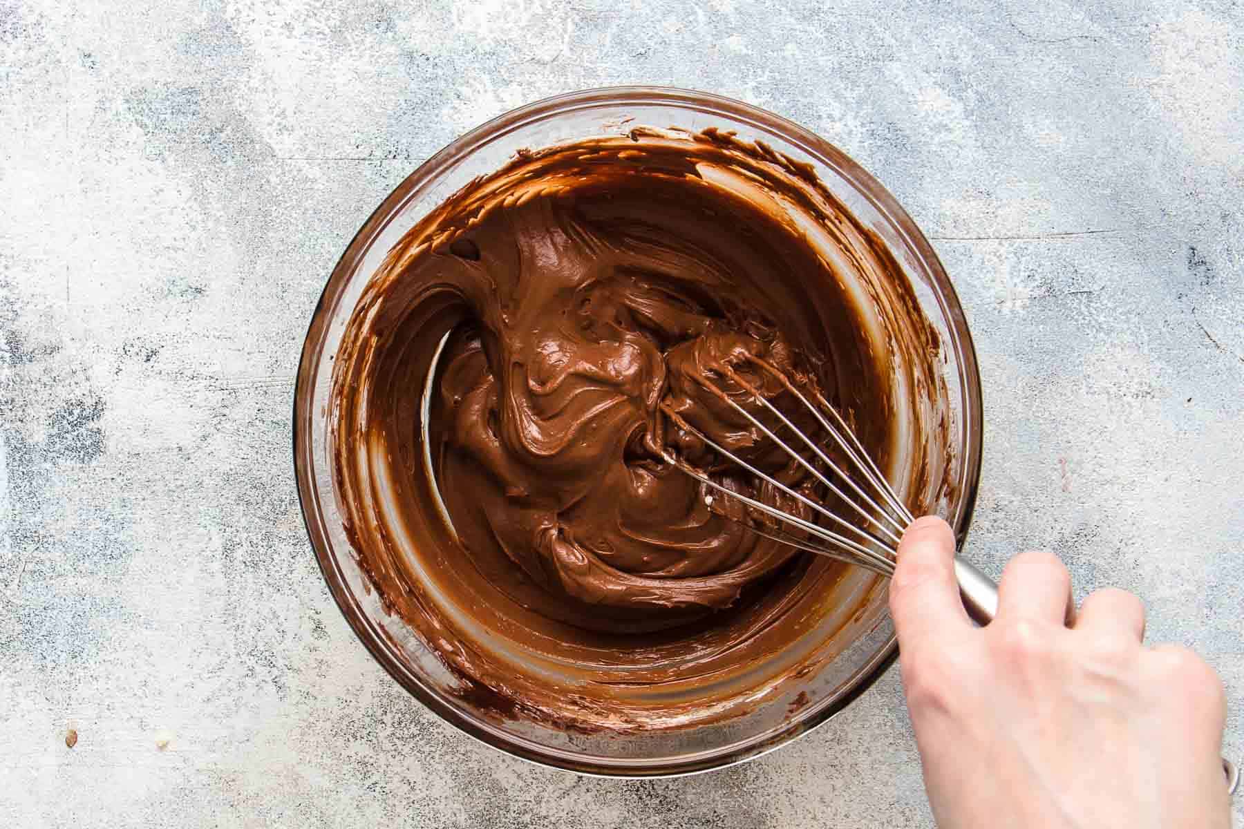 stirring chocolate mousse with whisk to lighten the texture