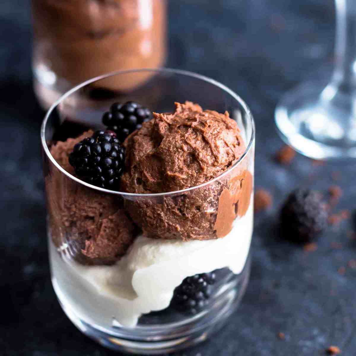 Chocolate Mousse in glass with whipping cream and blackberries