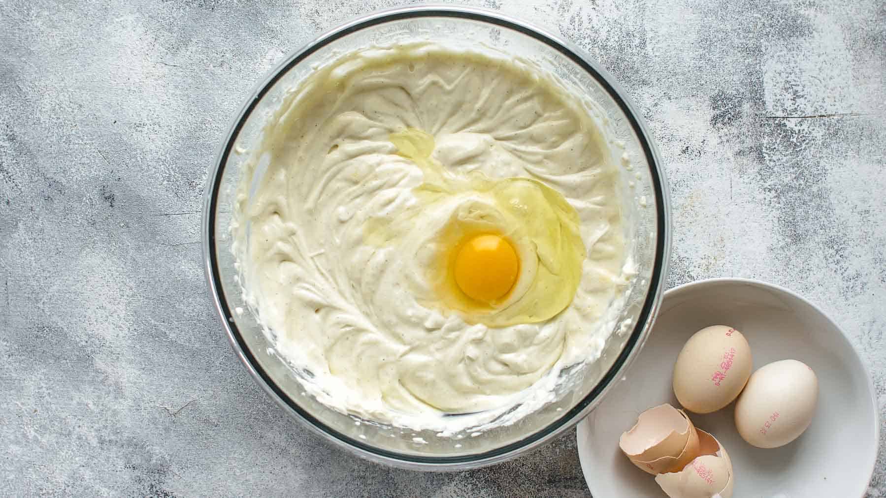 Adding the second egg to the coconut cheesecake batter