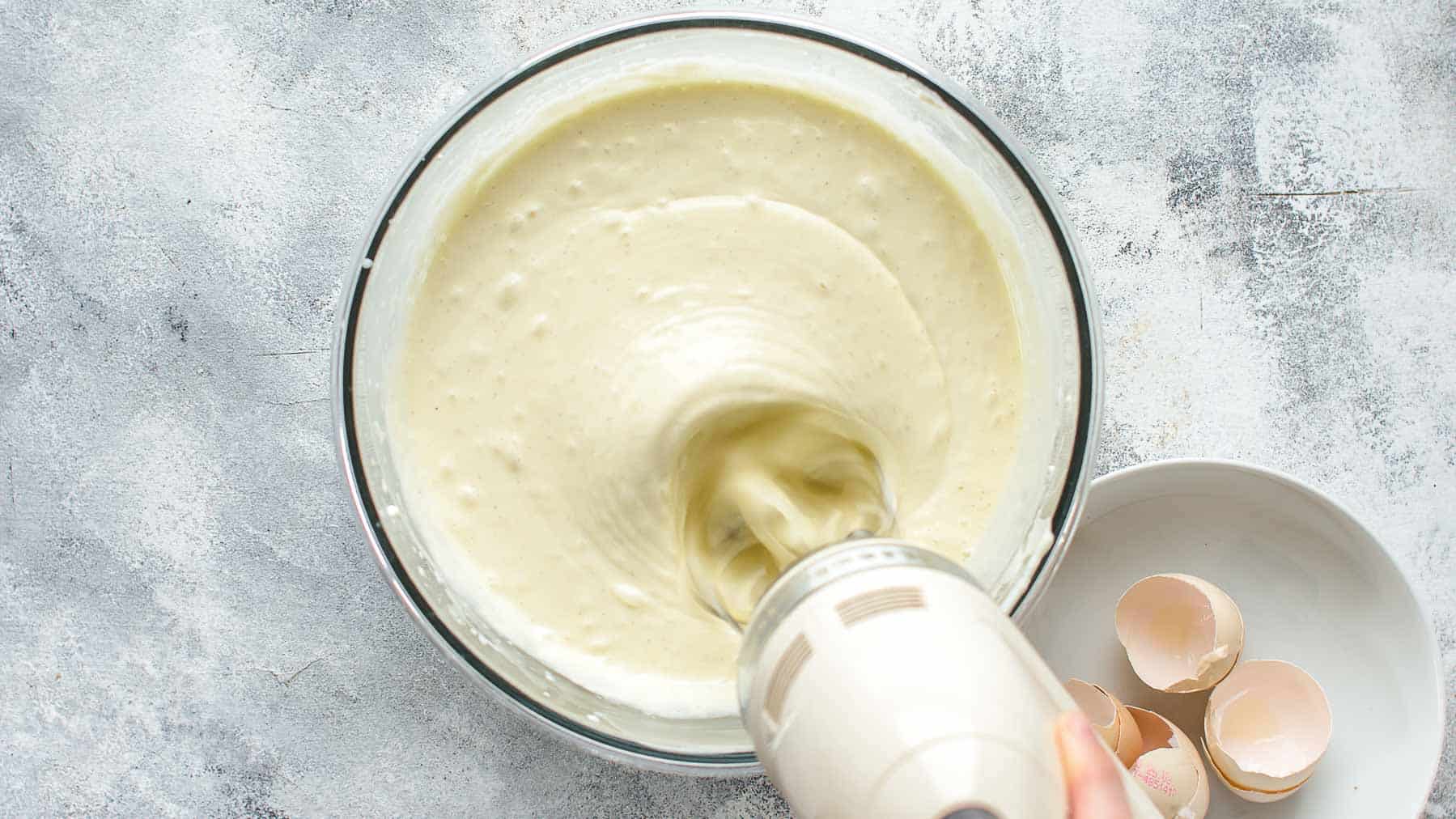mixing eggs into cheesecake filling with mixer