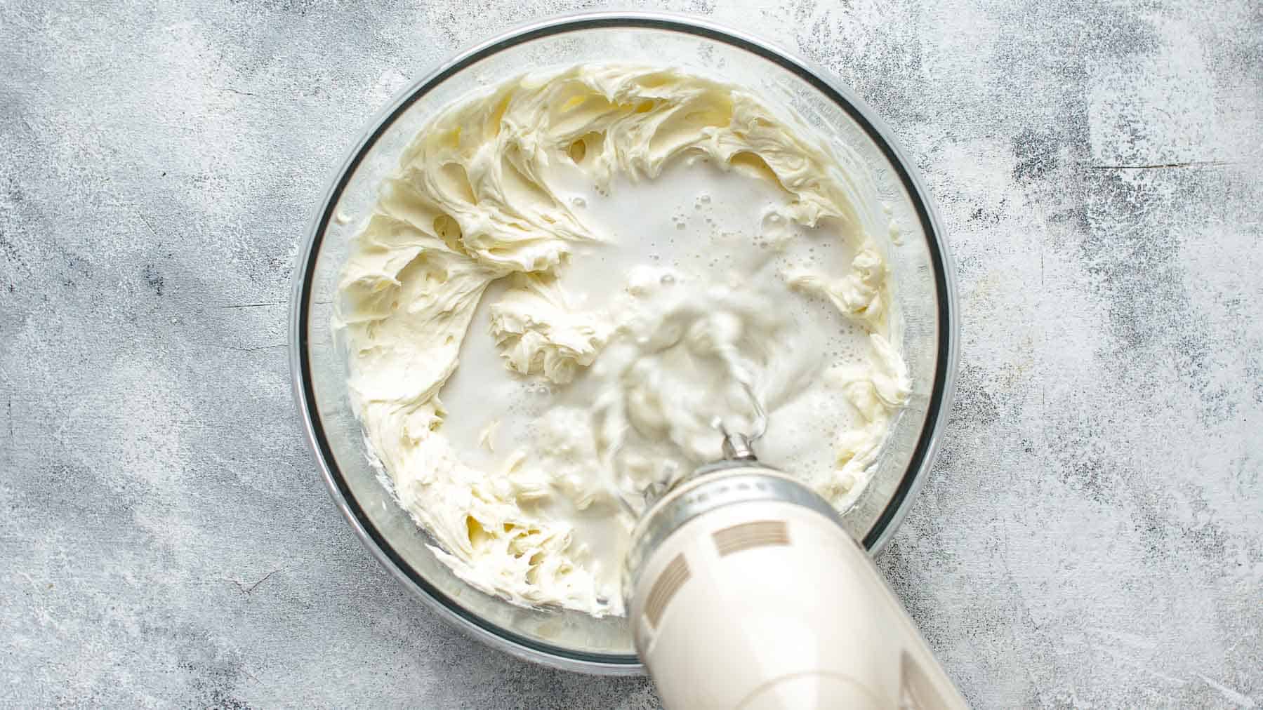 Adding the coconut milk and the vinegar to the coconut cheesecake batter