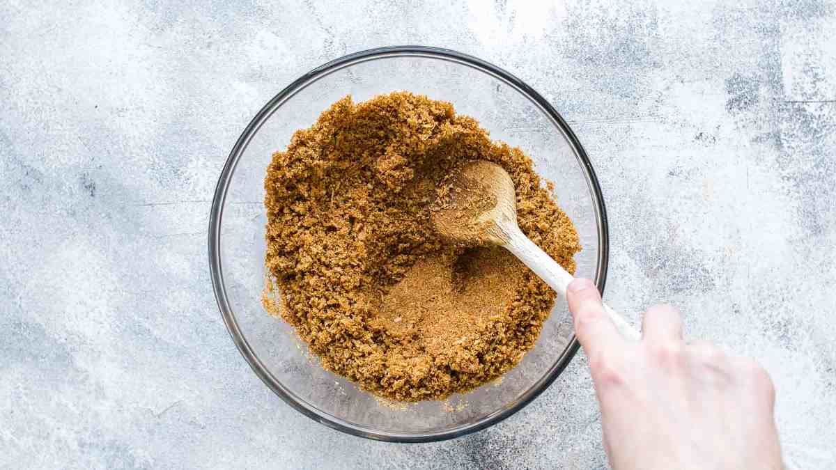 Stirring coconut graham cracker crumbs in a large mixing bowl