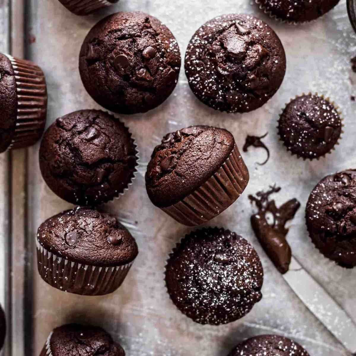a dozen chocolate muffins on a silver tray