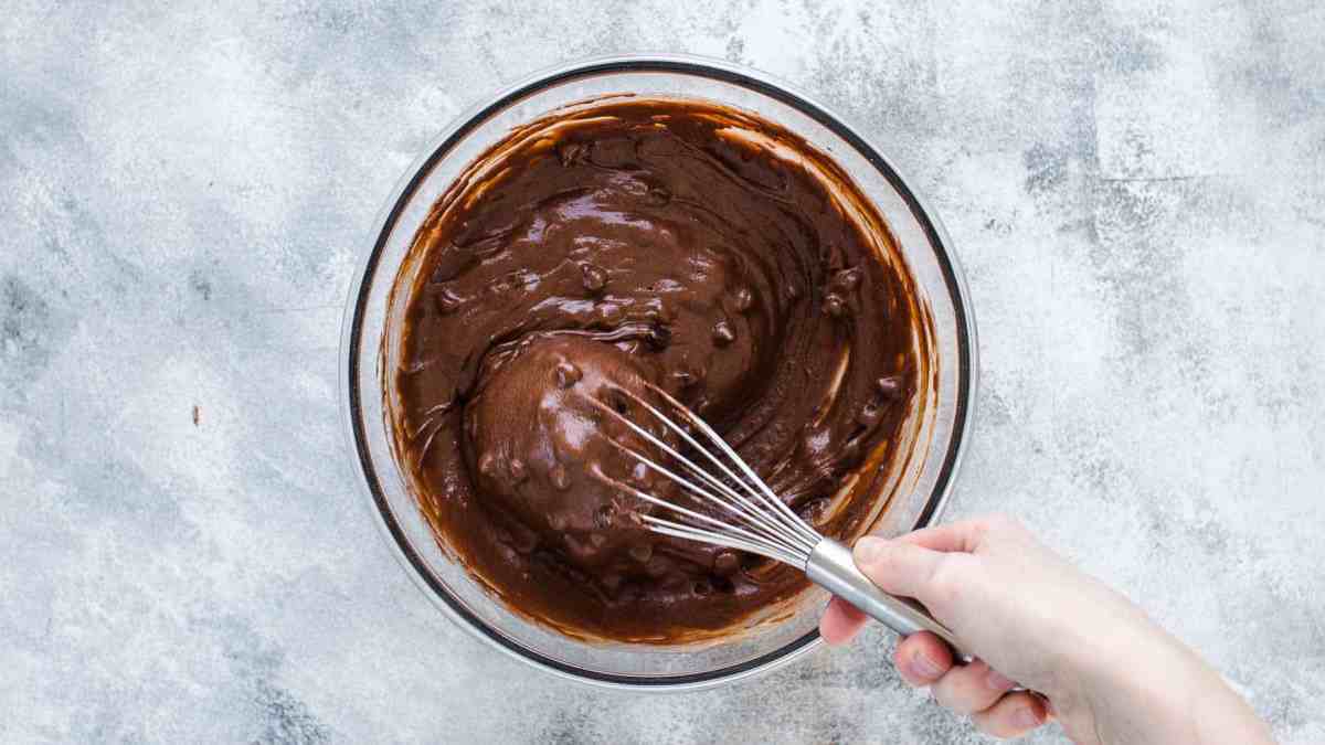 Overhead shot of whisking chocolate muffins batter in a large mixing bowl