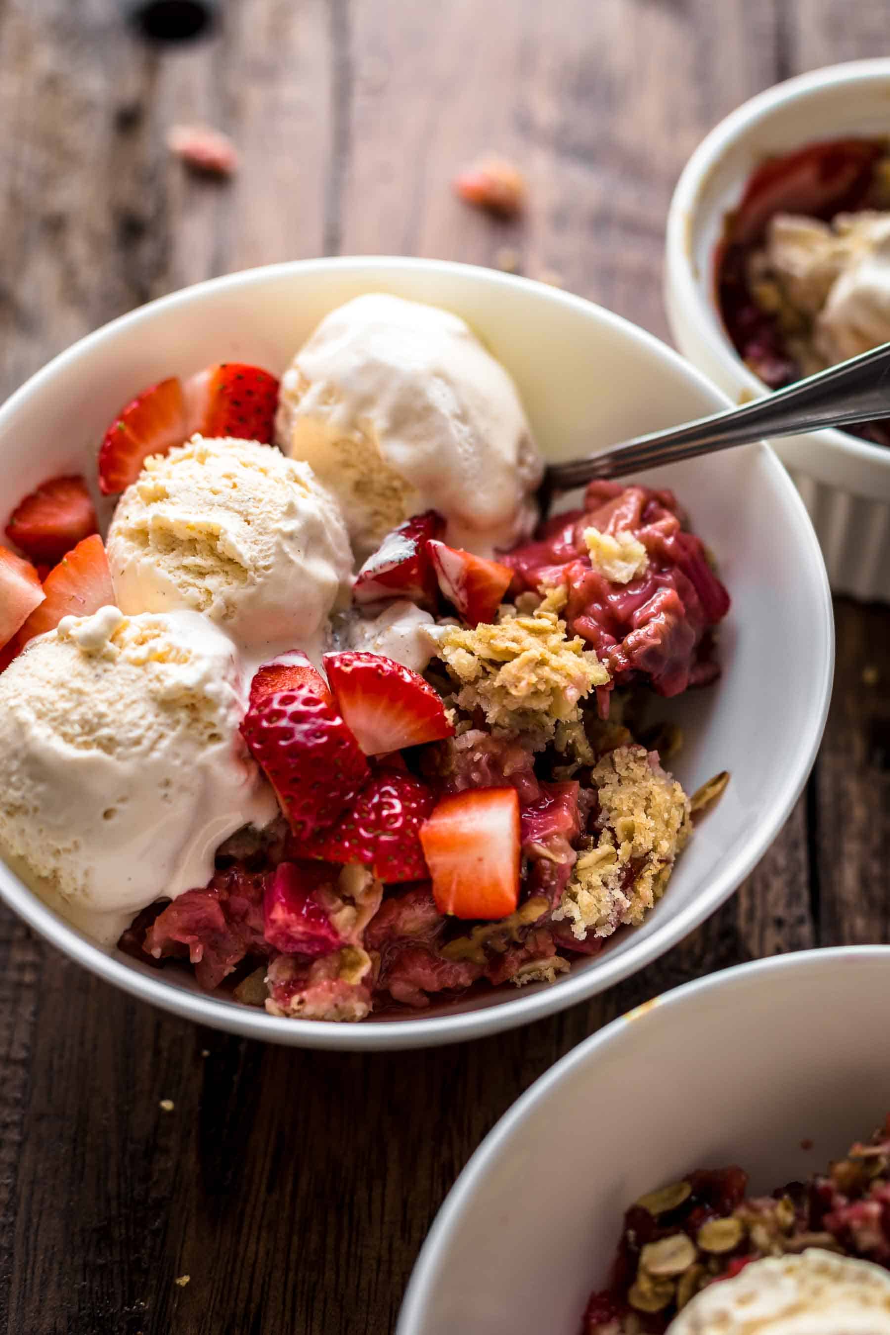 Strawberry Rhubarb Crisp with spoon in white bowl