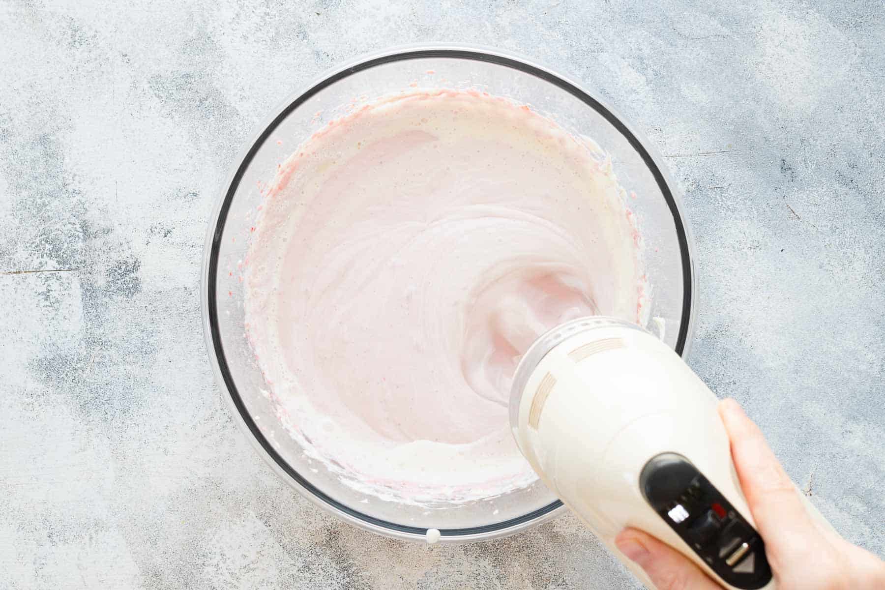 mixing whipping cream into strawberry cream cheese mixture with mixer