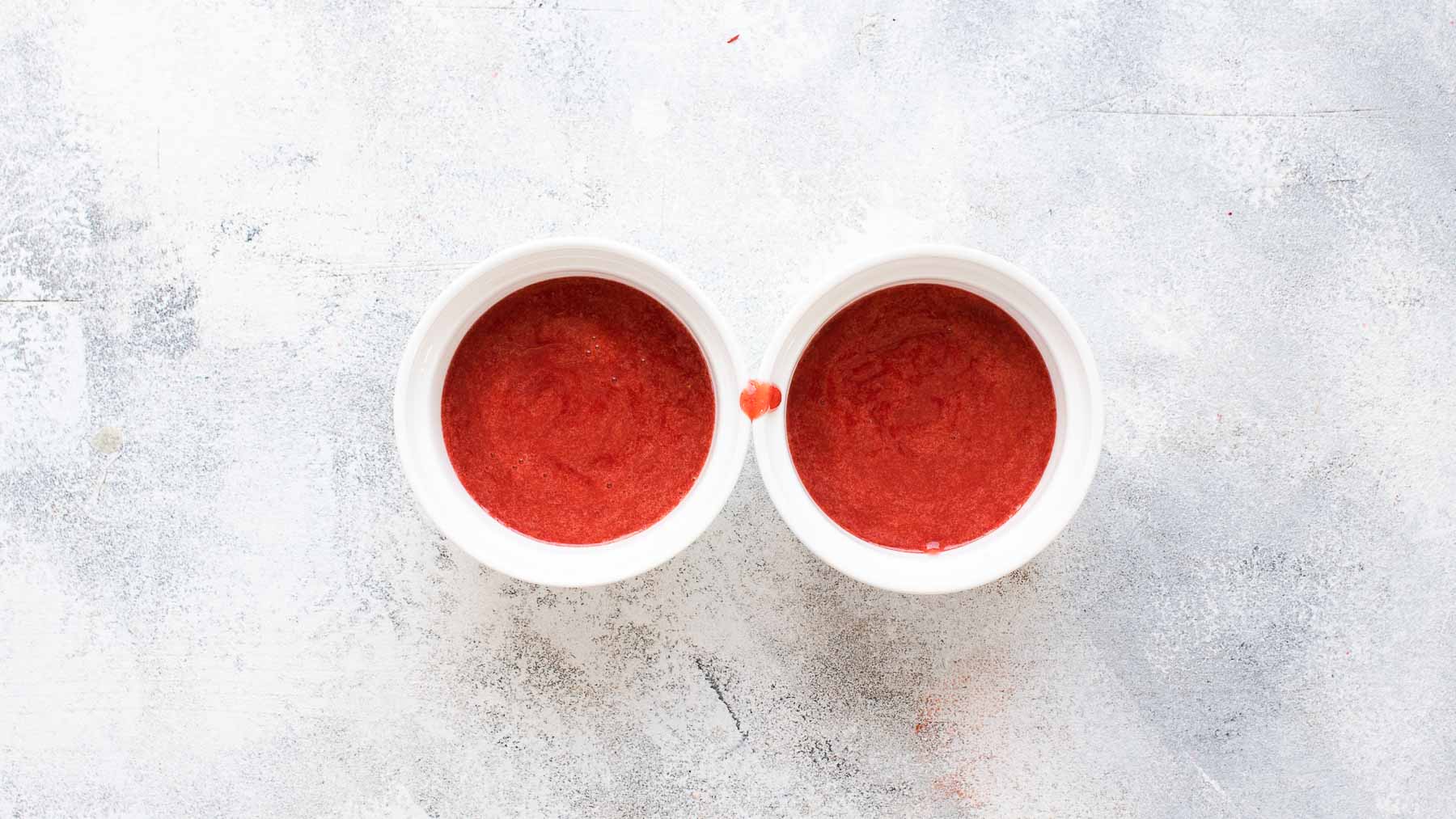 strawberry sauce in two ramekins next to each other