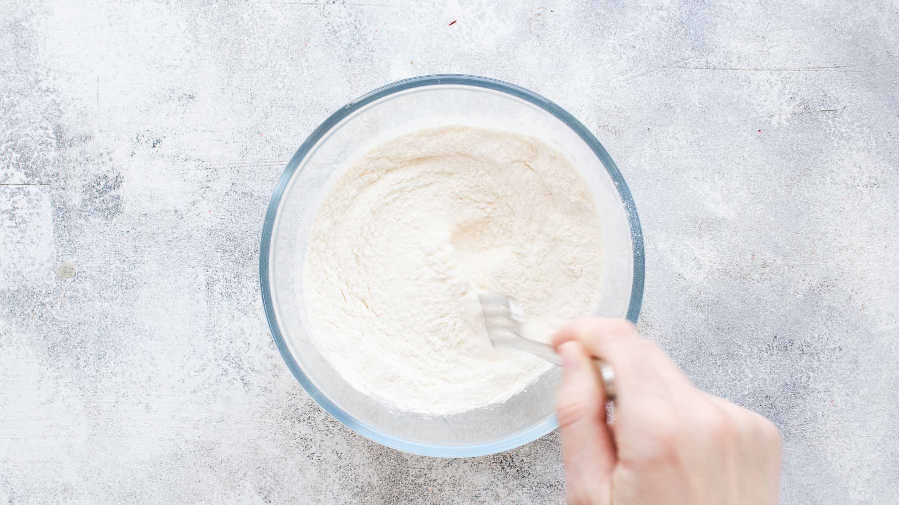 combining flour, baking powder, and salt in mixing bowl