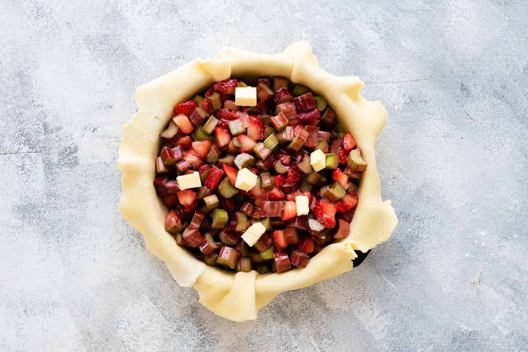 raw piecrust with strawberry rhubarb filling
