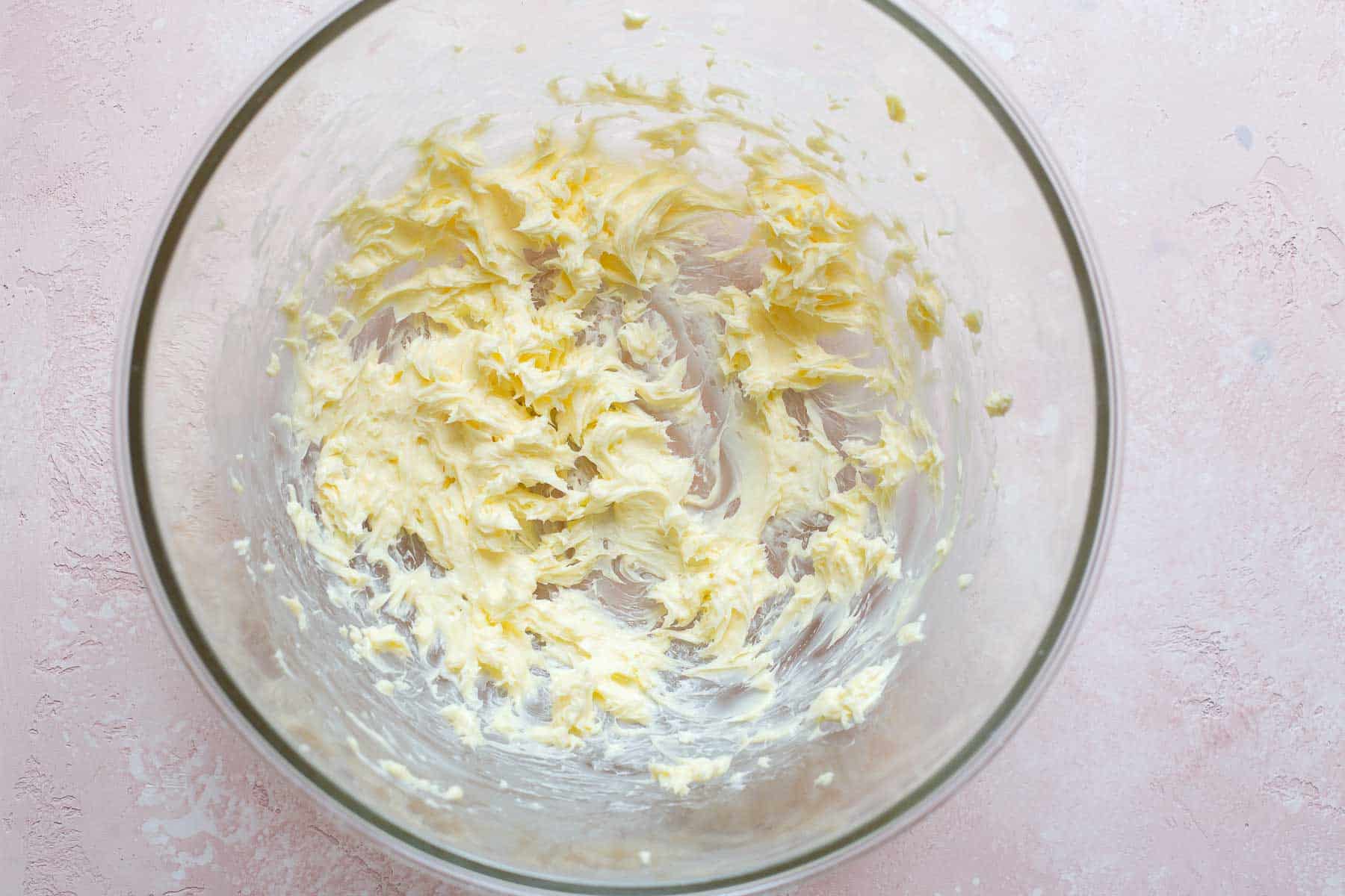 mixed butter in glass bowl on pink surface