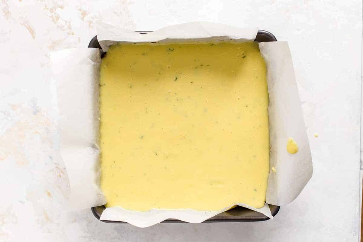 key lime bar batter in pan with parchment paper