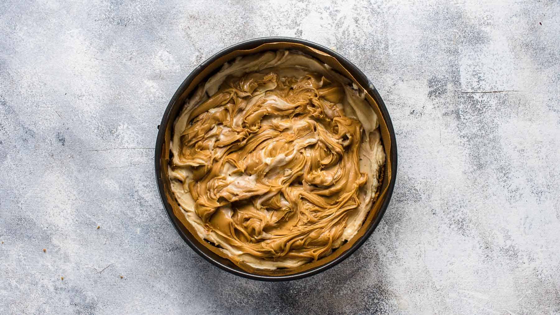 peanut butter swirls on top of ice cream in a springform pan