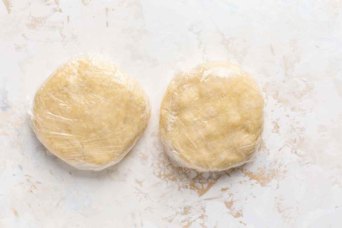 pie crust dough wrapped in plastic on counter