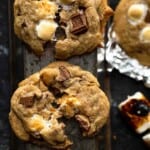 baked s'mores cookies broken apart in the center showing the gooey, melted marshmallows in the cookies
