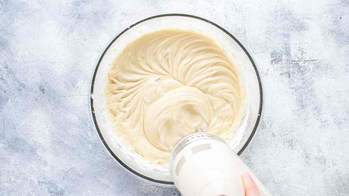 adding more flour into batter with hand mixer