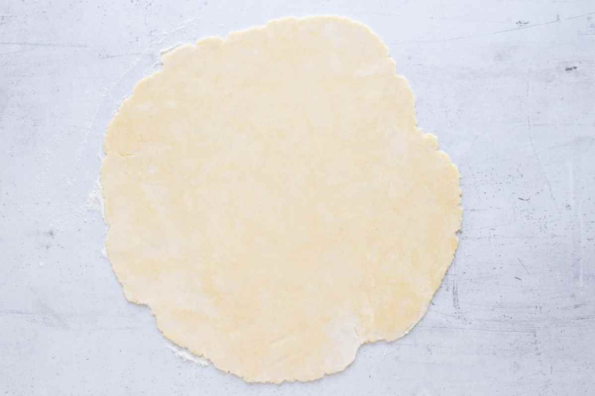 homemade pie crust rolled out on marble counter