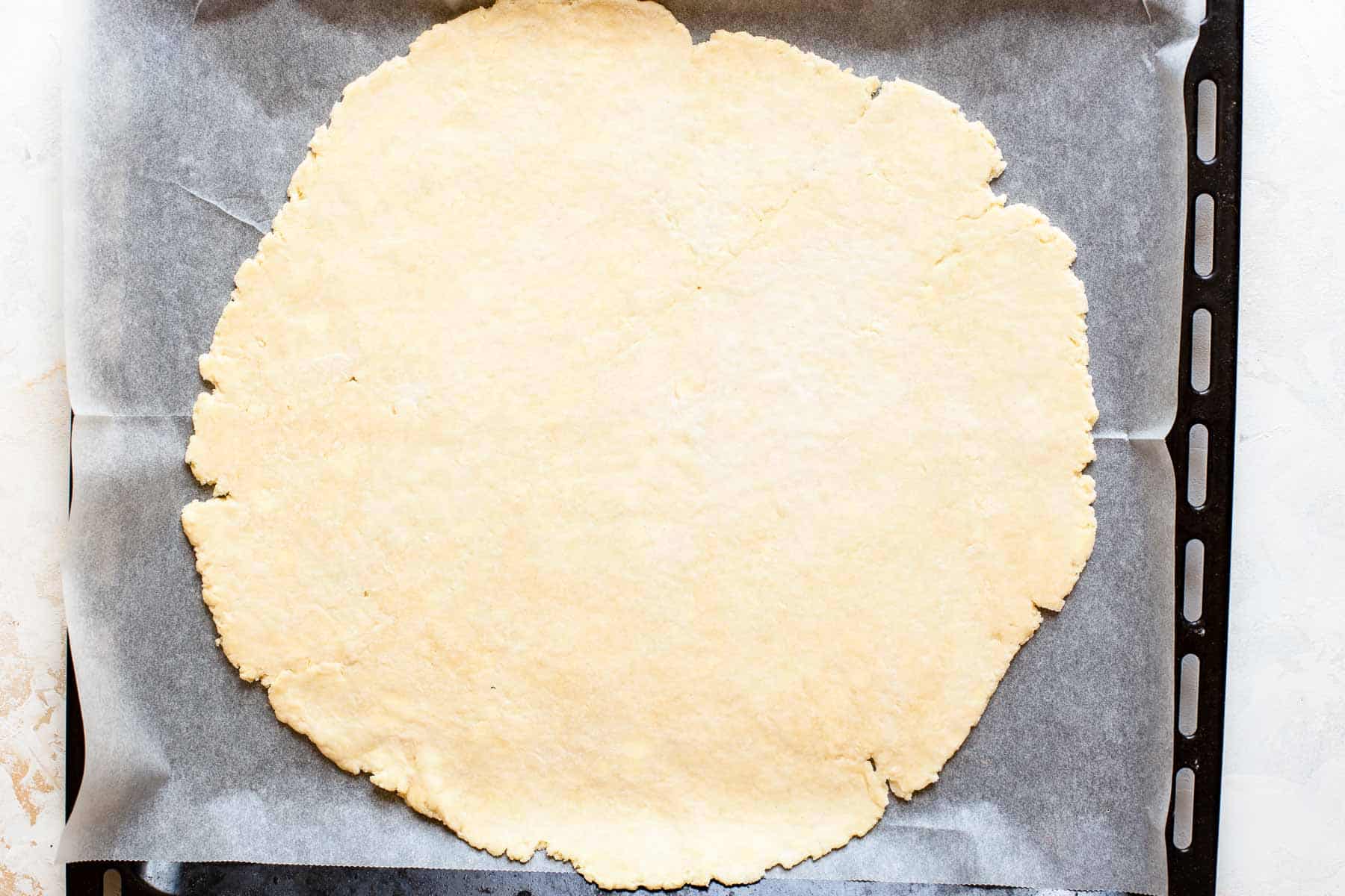 rolled out pie crust on a baking sheet