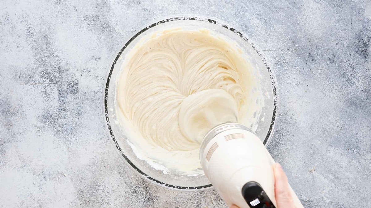 whipping up frosting for cake until creamy