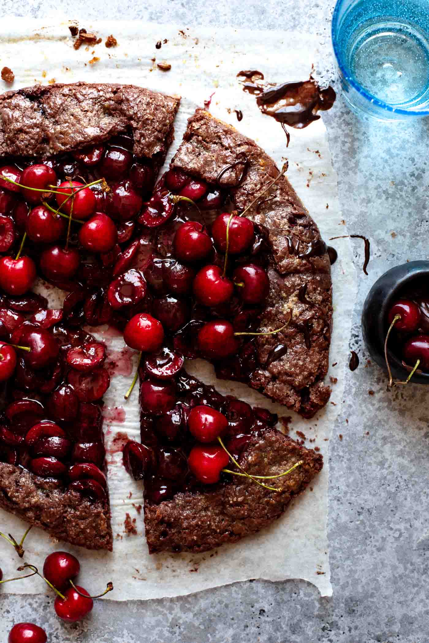 sliced chocolate galette with cherry filling on a grey table