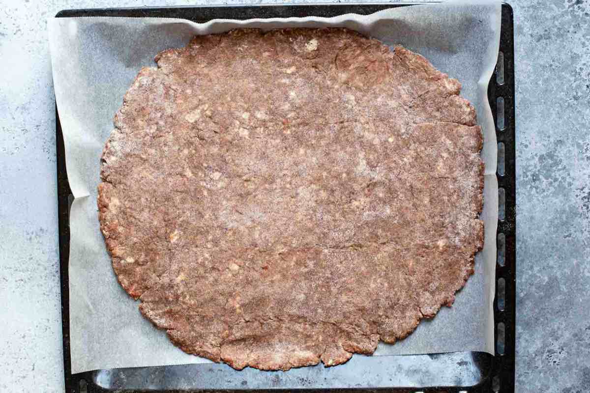 chocolate pie crust flattened out on parchment paper