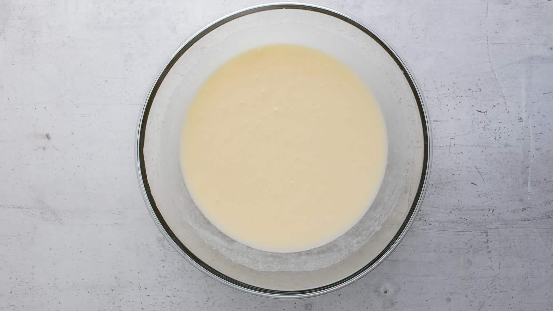 all wet ingredients of cake batter in a glass bowl
