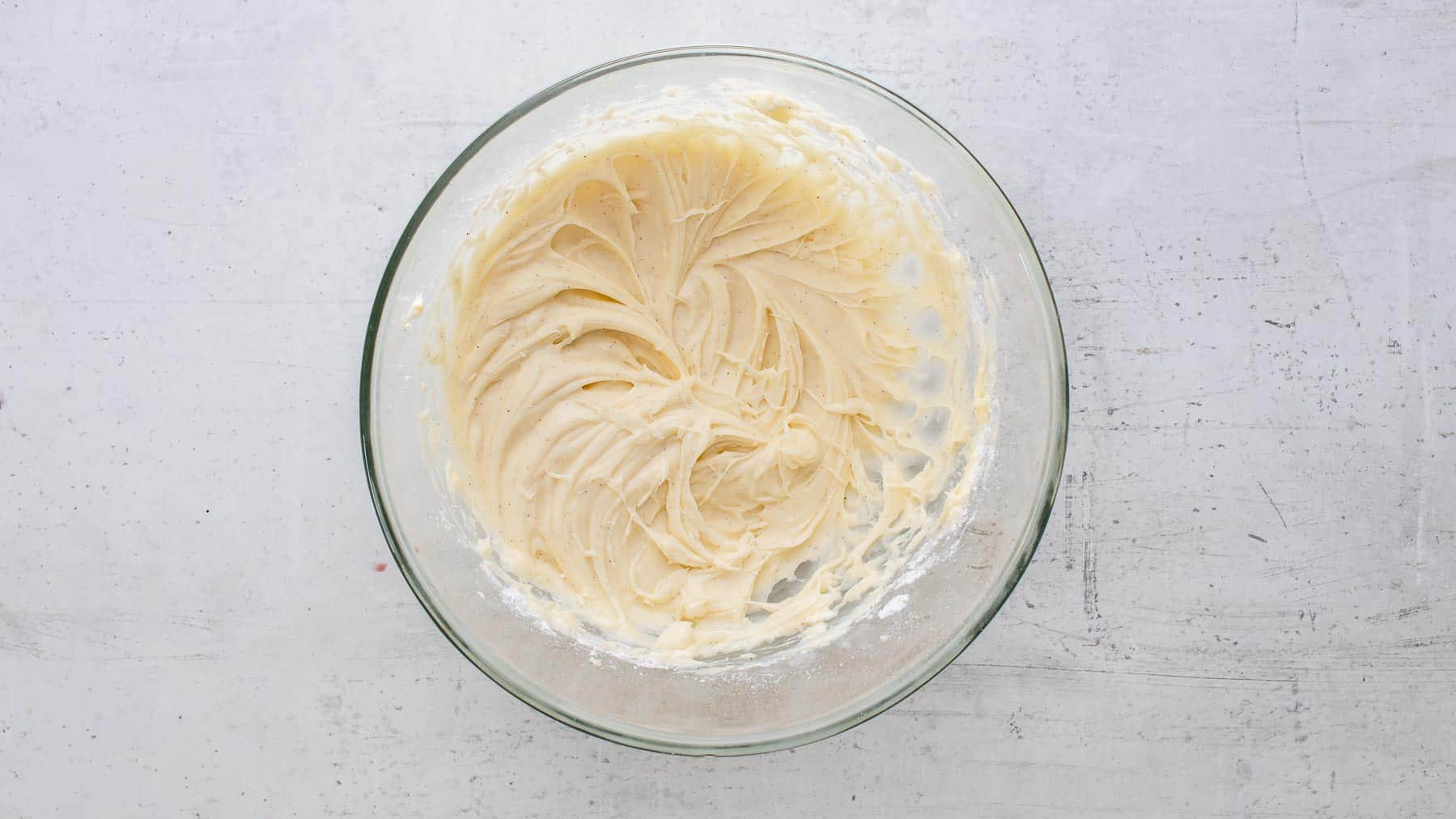 mixed cream cheese frosting in a glass bowl