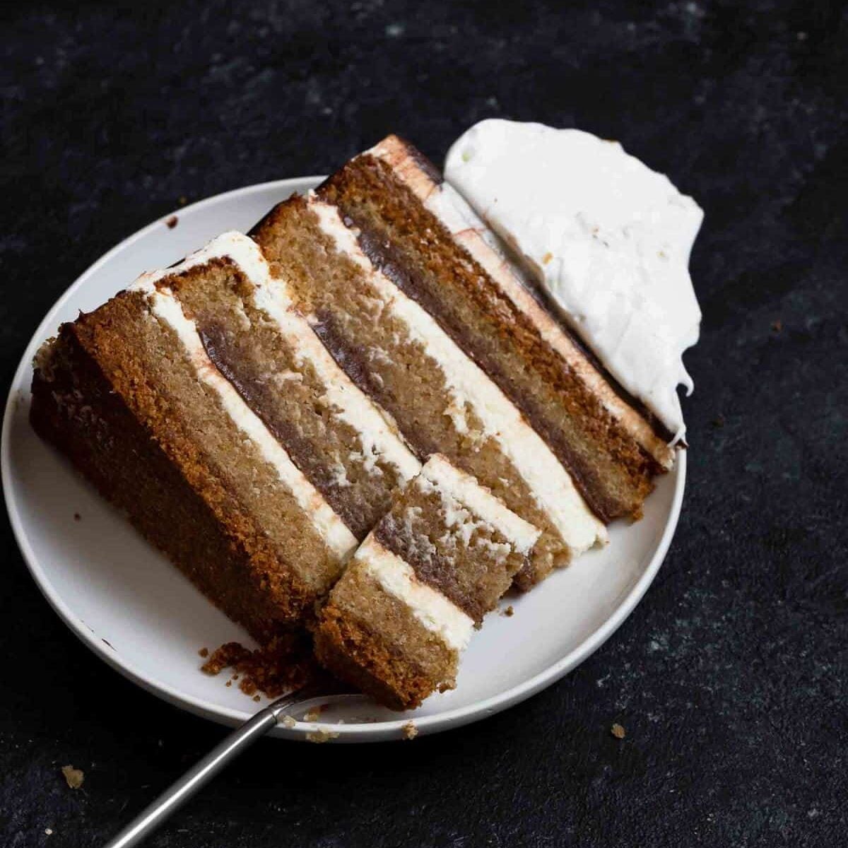 slice of s'mores layer cake on a serving plate with a fork