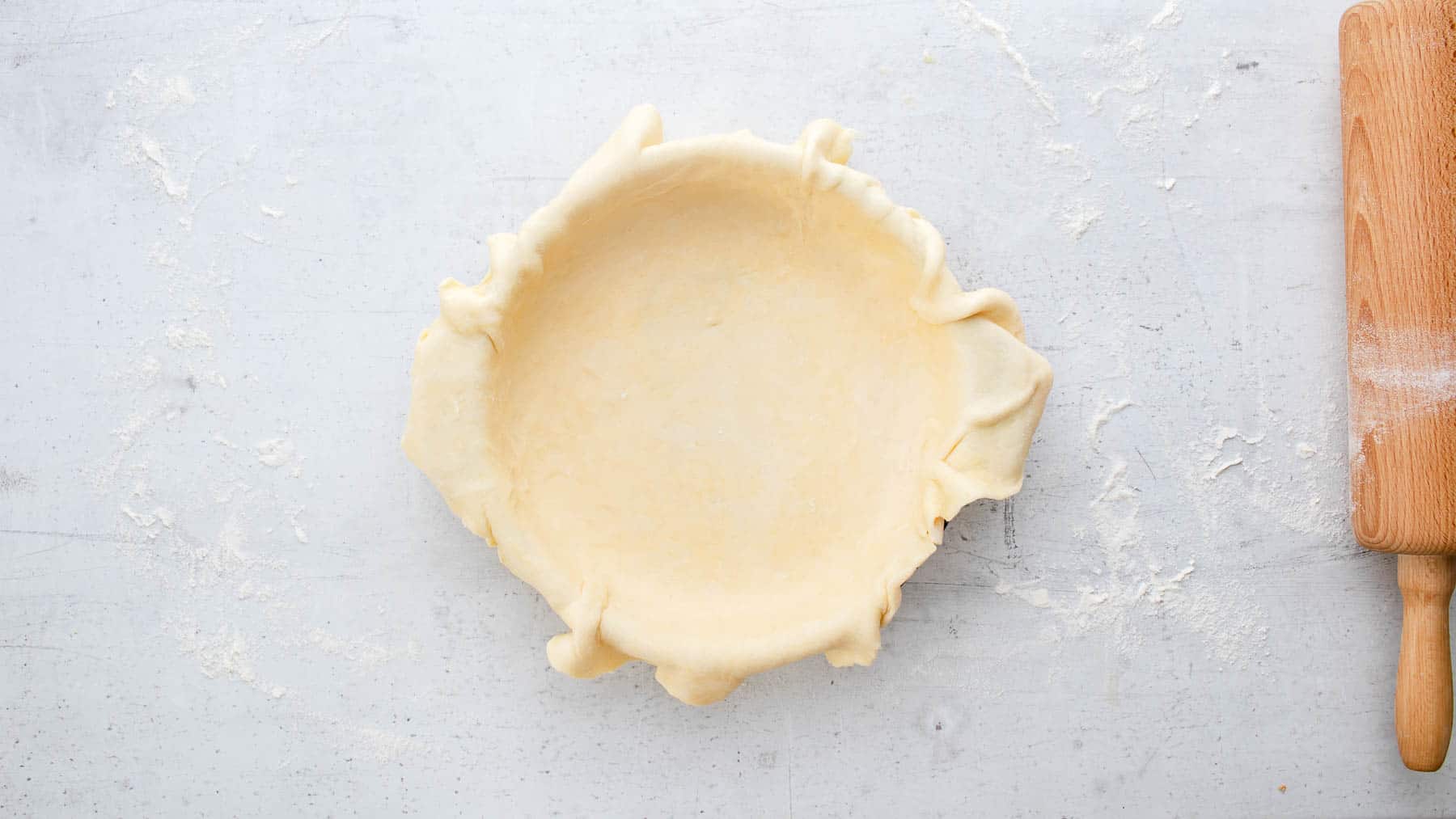 rolled out pie crust placed in baking dish