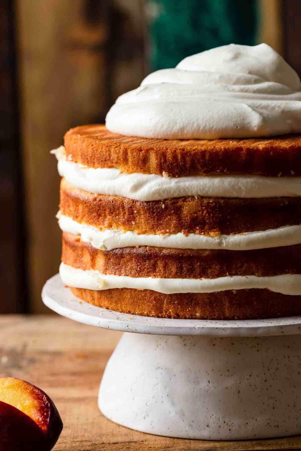 peaches and cream cake on a cake stand