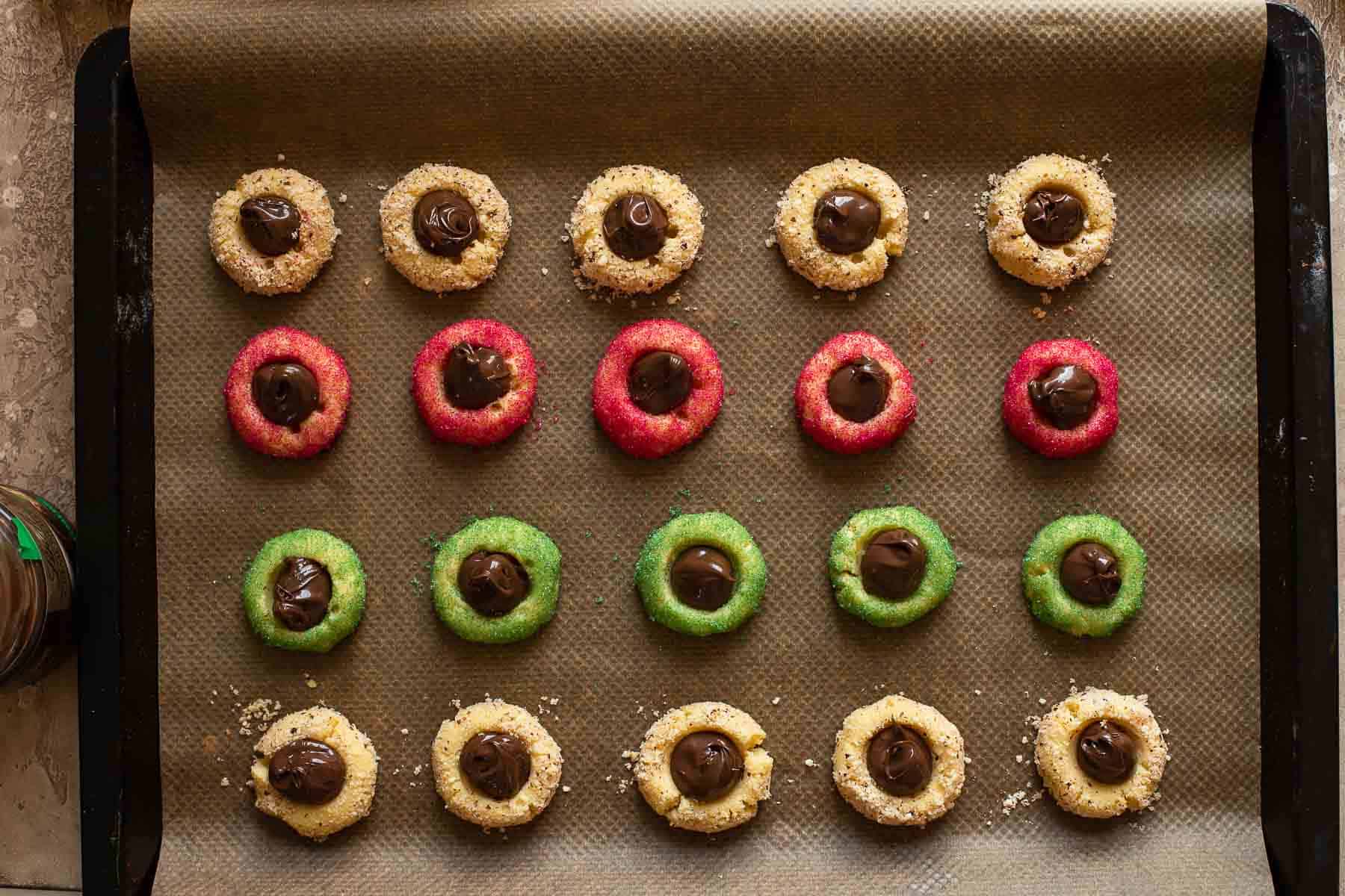 baking sheet with baked and filled thumbprint cookies