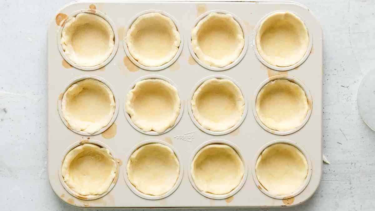 muffin tin with pie crust in each hole