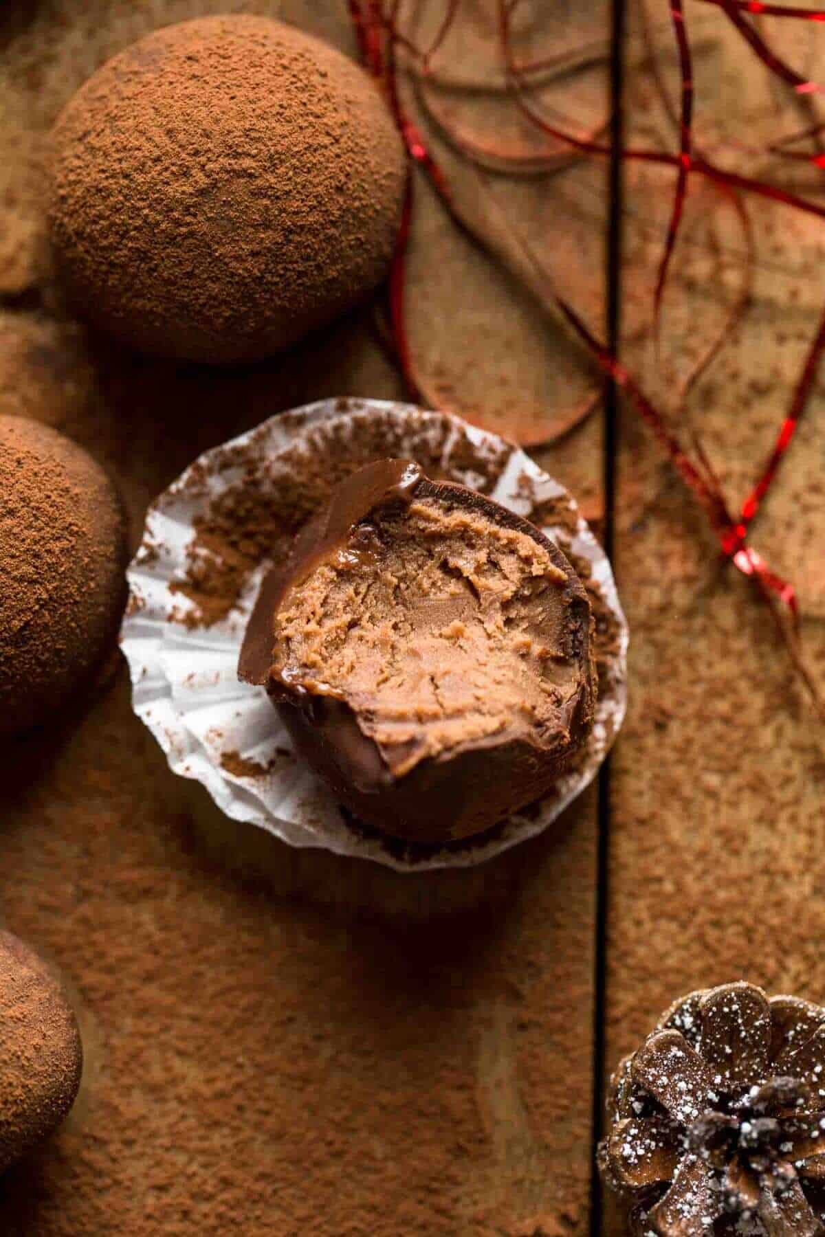 bitten chocolate rum truffle on brown background