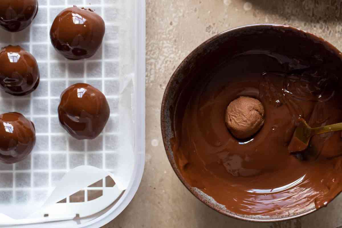 rum truffles being dipped in melted chocolate