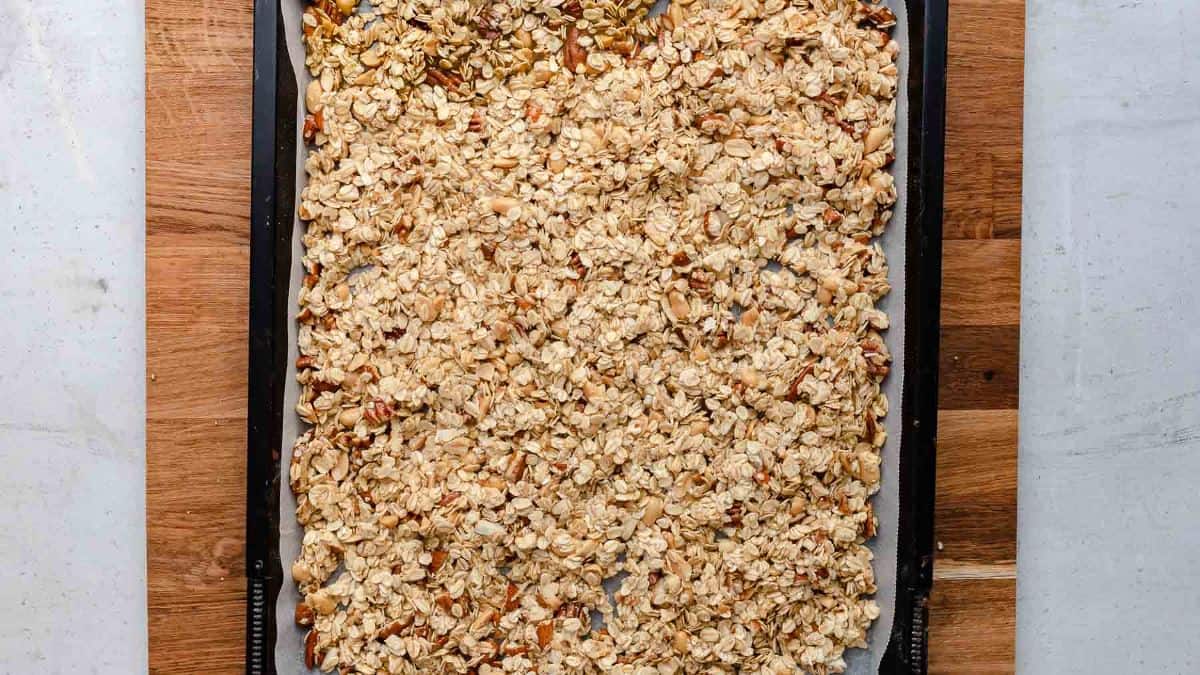 granola layered out on pan ready to be baked
