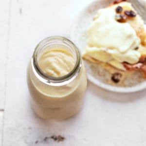 Decorative picture of custard in glass with bread pudding next to it on bright background