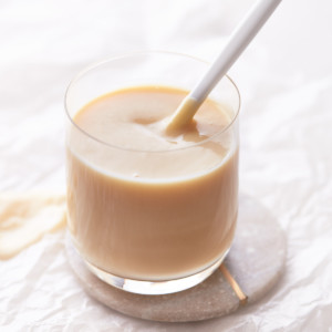 Decorative picture of condensed milk in a glass with a spoon in it