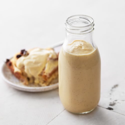 Decorative picture of custard in a glass jar shown from the side