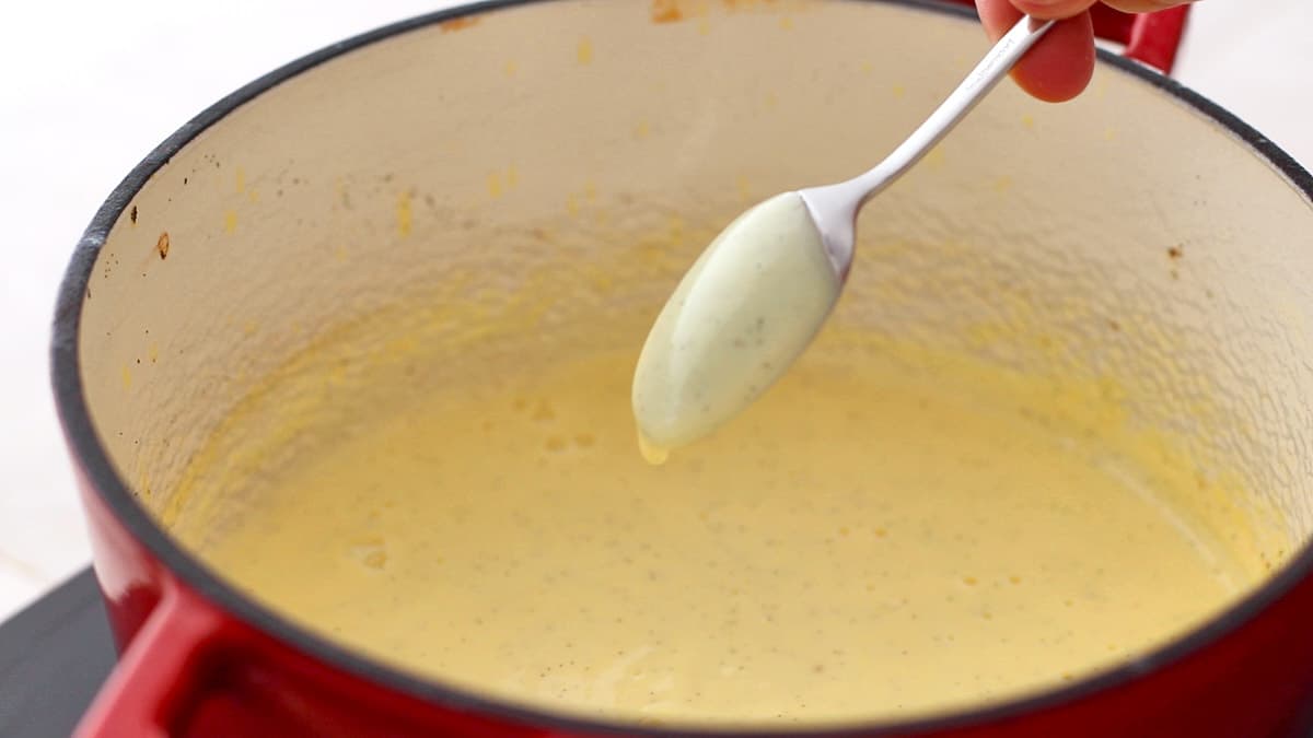 The back of a spoon is coated with egg custard and shown into the camera