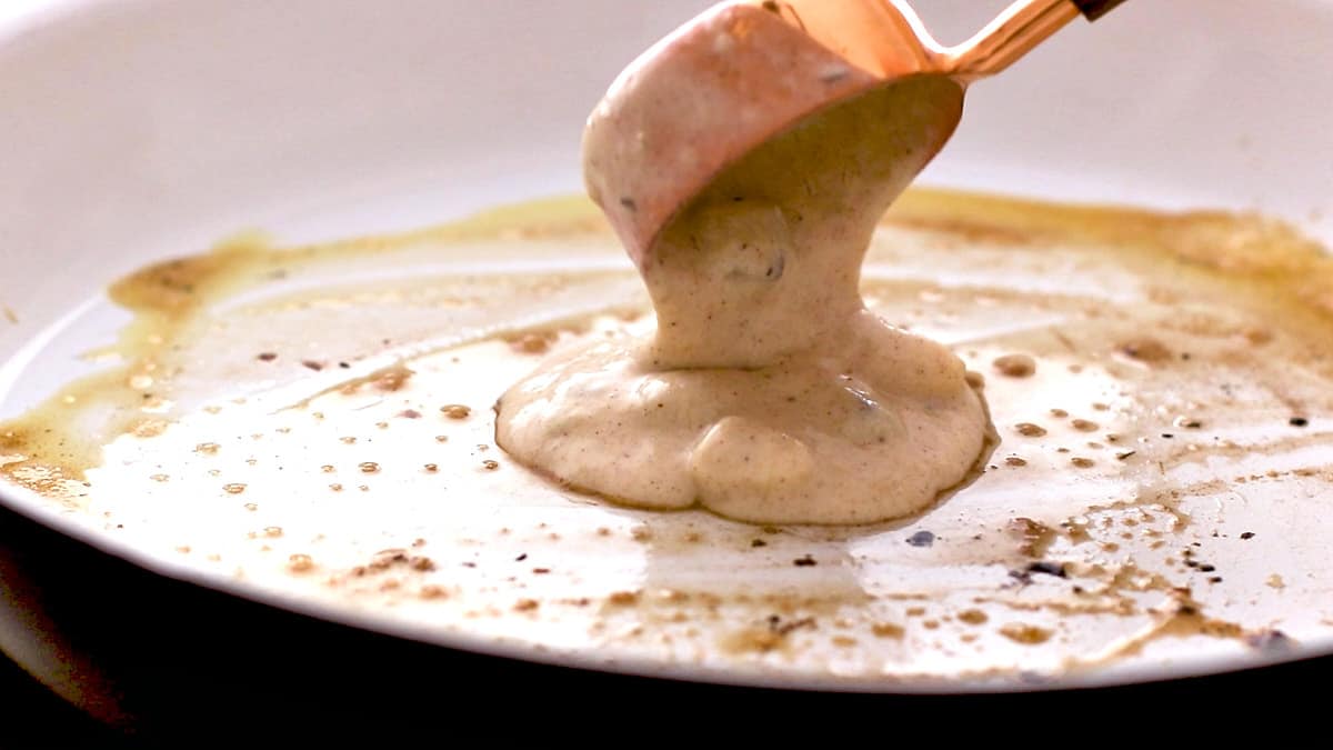 Scooping pancakes batter into heated pan
