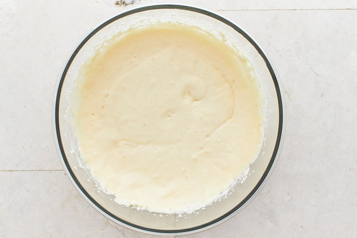 Cream cheese, sugar, and eggs mixed in a large mixing bowl