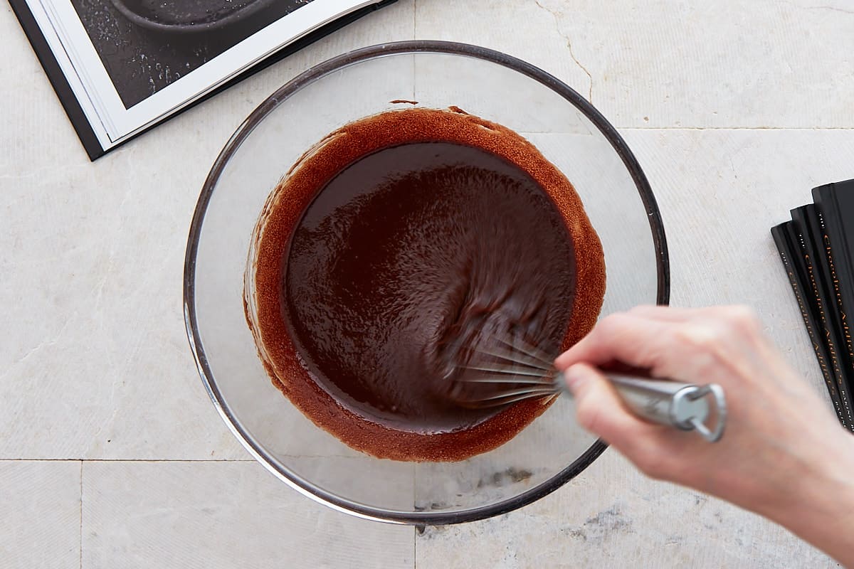 Whisking chocolate, butter, sugar, vanilla, and salt in a large bowl