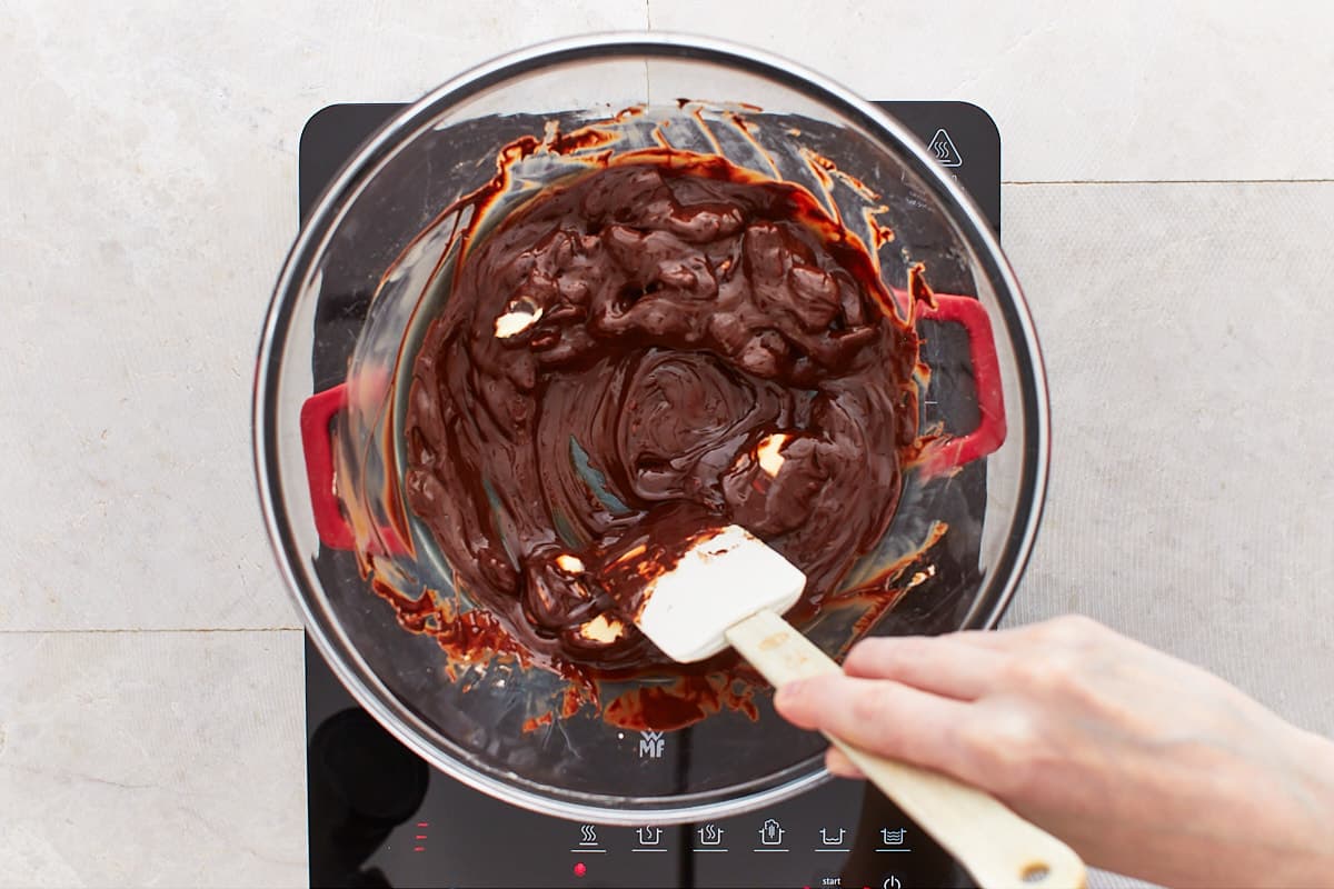 Melting chocolate and butter in a large bowl placed over a saucepan on low heat