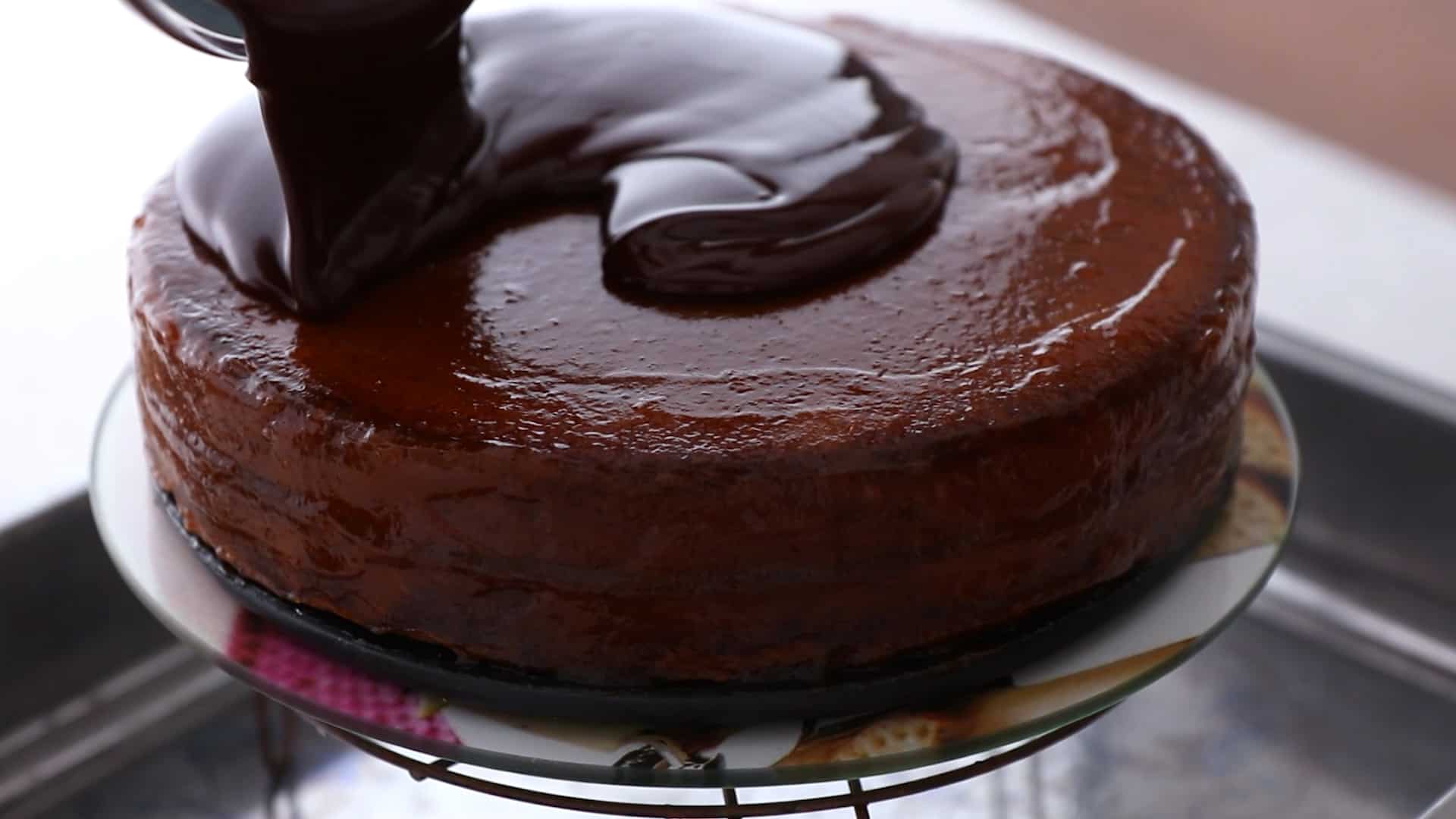 Pouring chocolate glaze over the chocolate cake