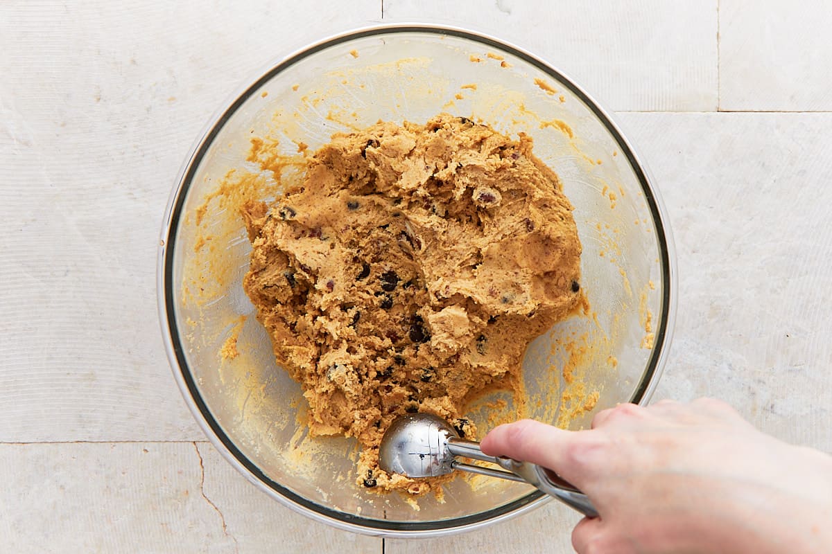 Scooping cookie dough with an ice cream scoop