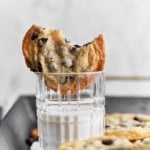 Bitten cookie on top of a glass half full with milk