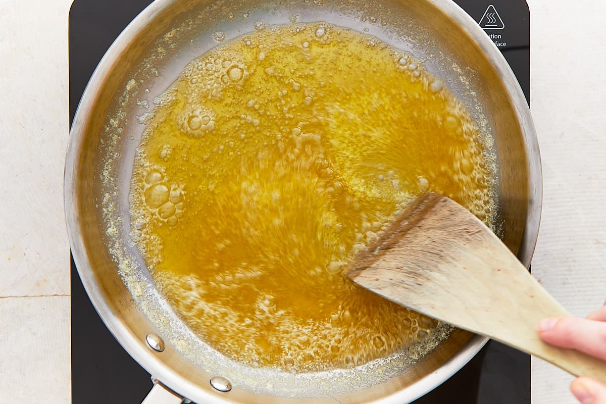 Stirring cooking butter with a wooden spatula