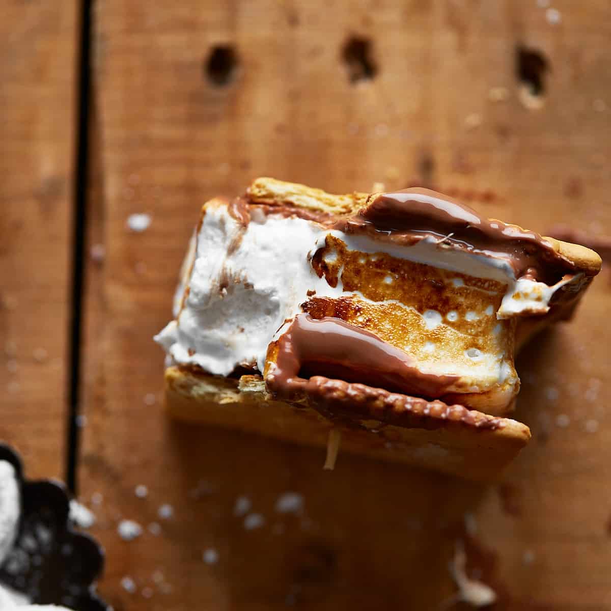 Bitten s'mores on a wooden background